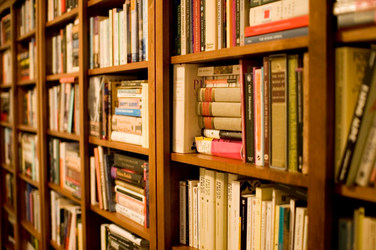 Tall wooden bookshelves in the Daruma library, densely packed with hardcover books