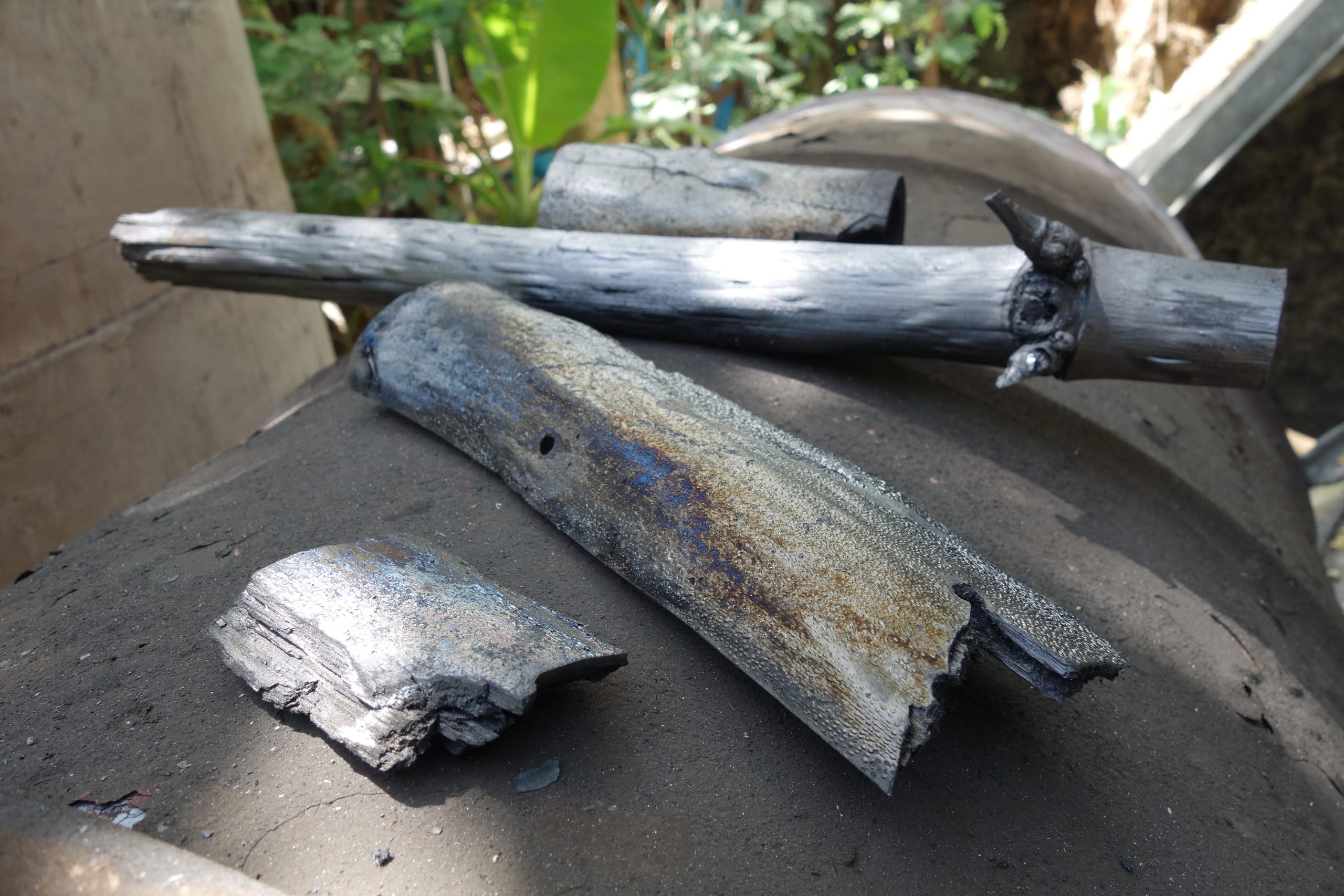 Pieces of bamboo charcoal cooling on a kiln lid after a burn