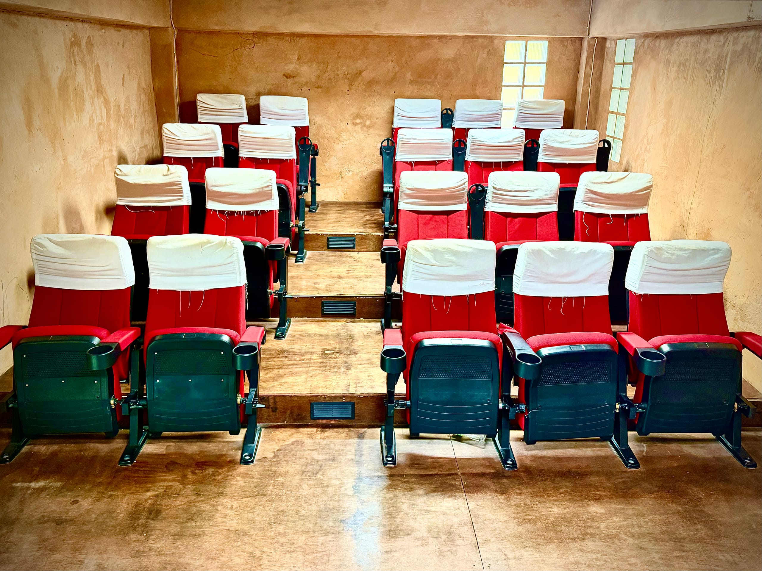 Rows of red auditorium seats in Mosaic School's performance room