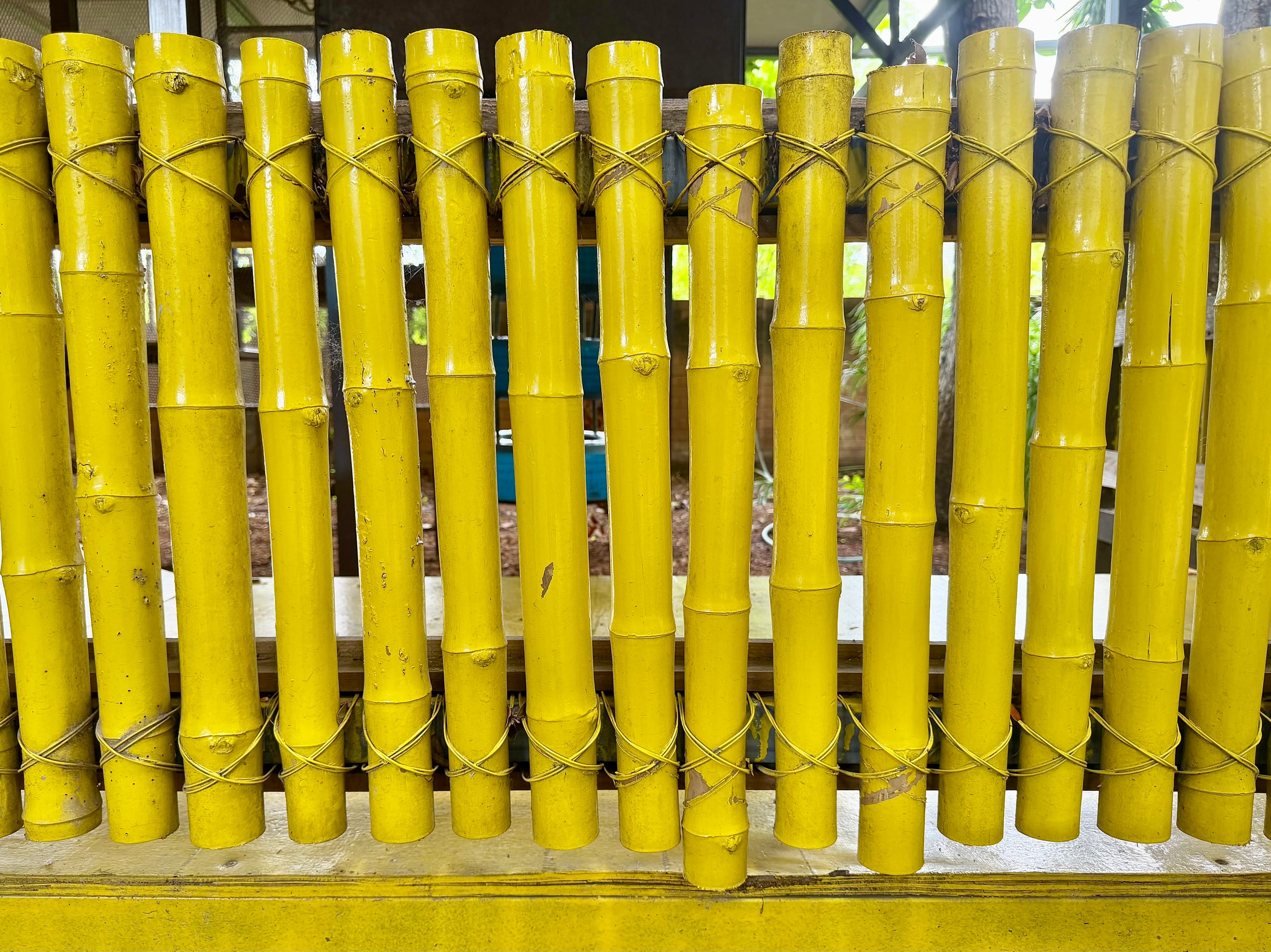 A row of bamboo poles painted bright yellow and lashed together