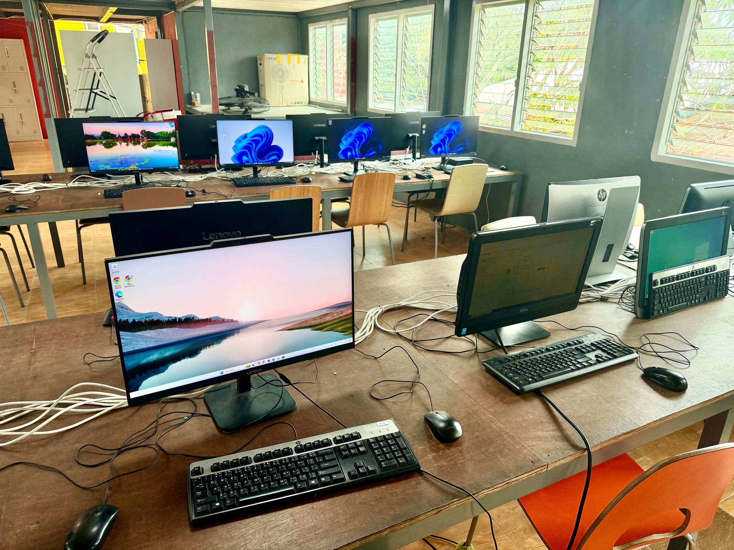 Inside the Mosaic School computer lab, rows of desks with monitors and keyboards