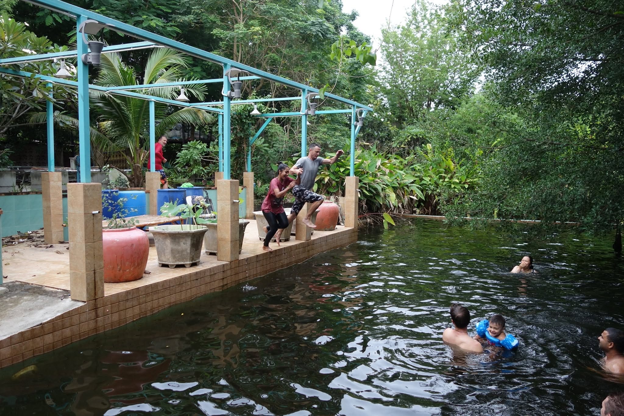 Students and families laughing and jumping into the natural swimming pool